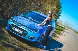 Милая красотка на фоне своего автомобиля