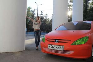 Хорошенькая девушка рядом со своим Peugeot