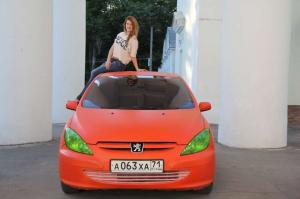 Хорошенькая девушка рядом со своим Peugeot