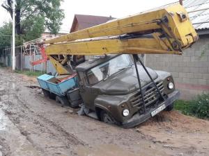 Автомобили проваливаются под землю в Алматы после дождя